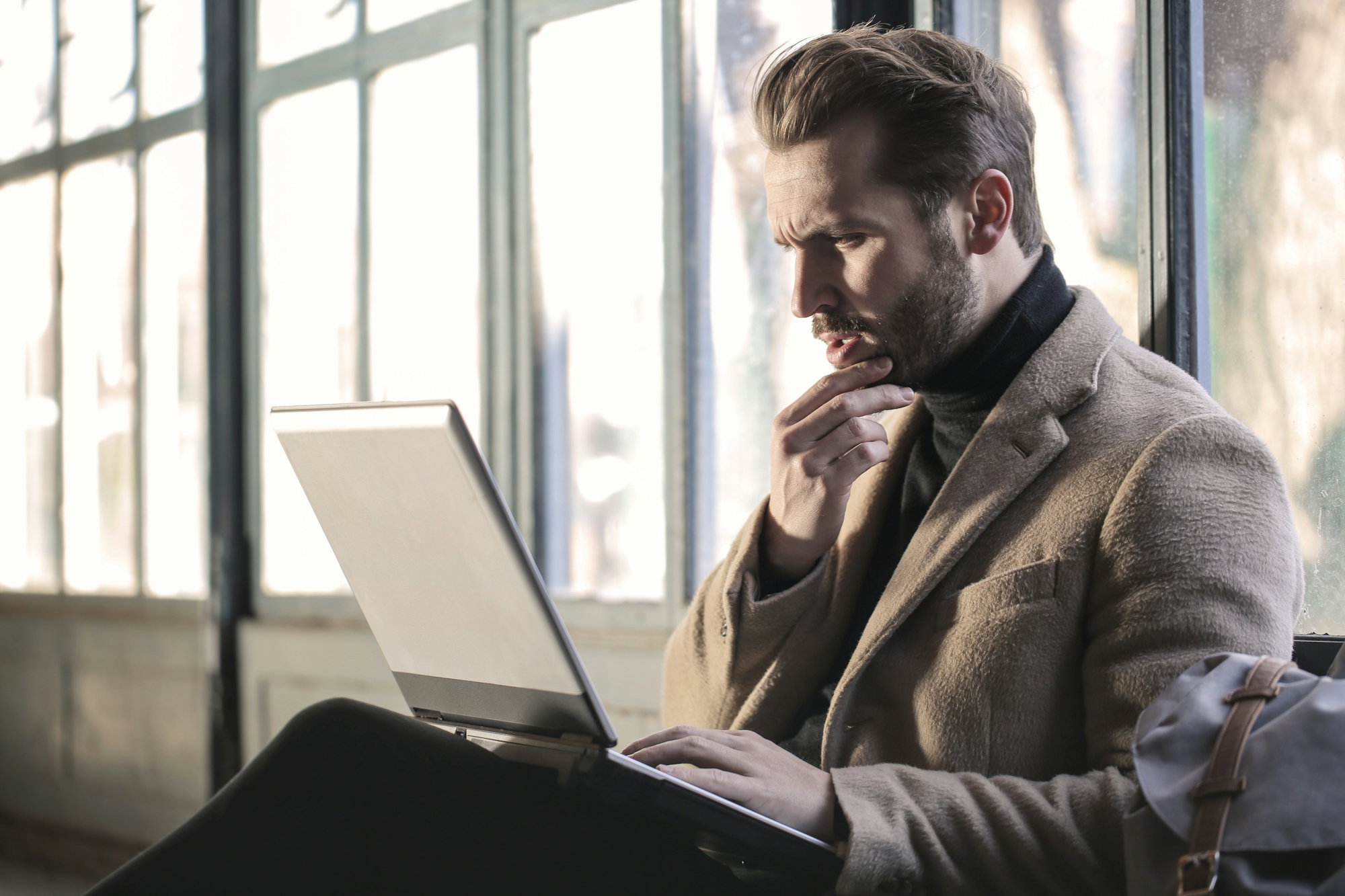 man-holding-his-chin-facing-laptop-computer.jpg man holding his chin facing laptop computer